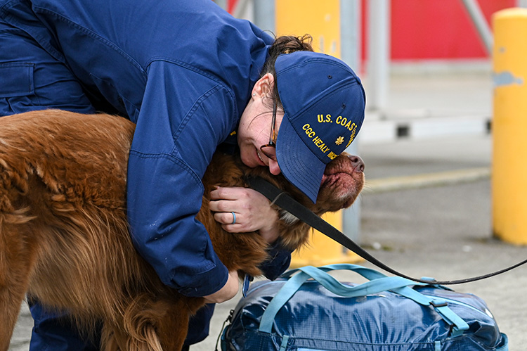 Coast guard woman hugging a dog