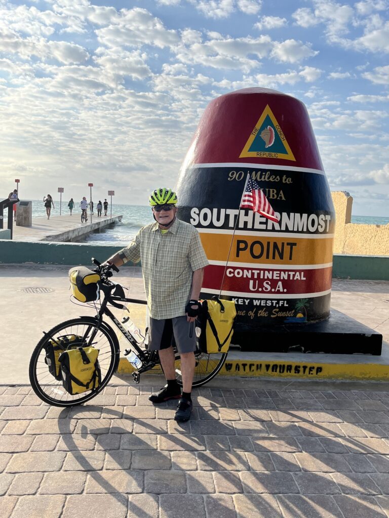 Vice Adm. Manson Brown, U.S. Coast Guard (Ret.), poses at the Southernmost Point Buoy in Key West, Florida, on Feb. 19, 2026, marking the start of his 2,200-mile bicycle ride to raise awareness and support for Coast Guard Mutual Assistance. (Photo courtesy of Manson Brown)